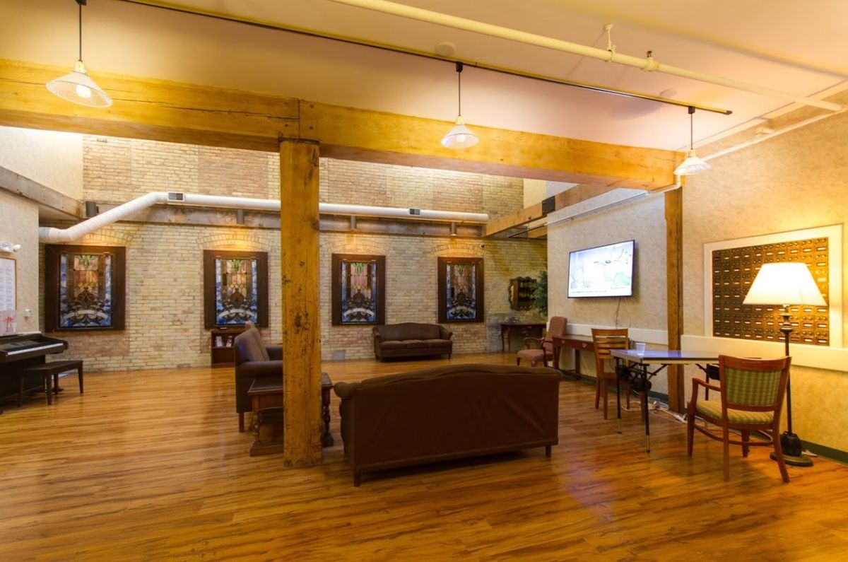 A cozy lounge area with comfortable seating, wooden flooring, and contemporary artwork on the walls.