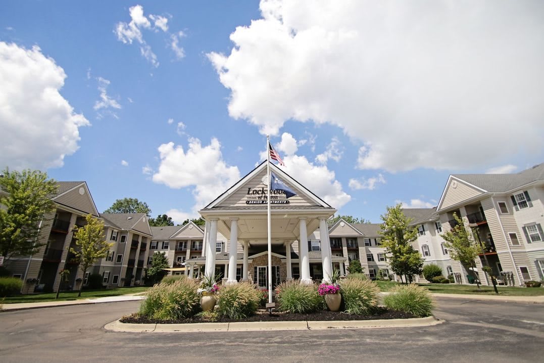 Elegant hotel entrance with columns and landscaped surroundings.