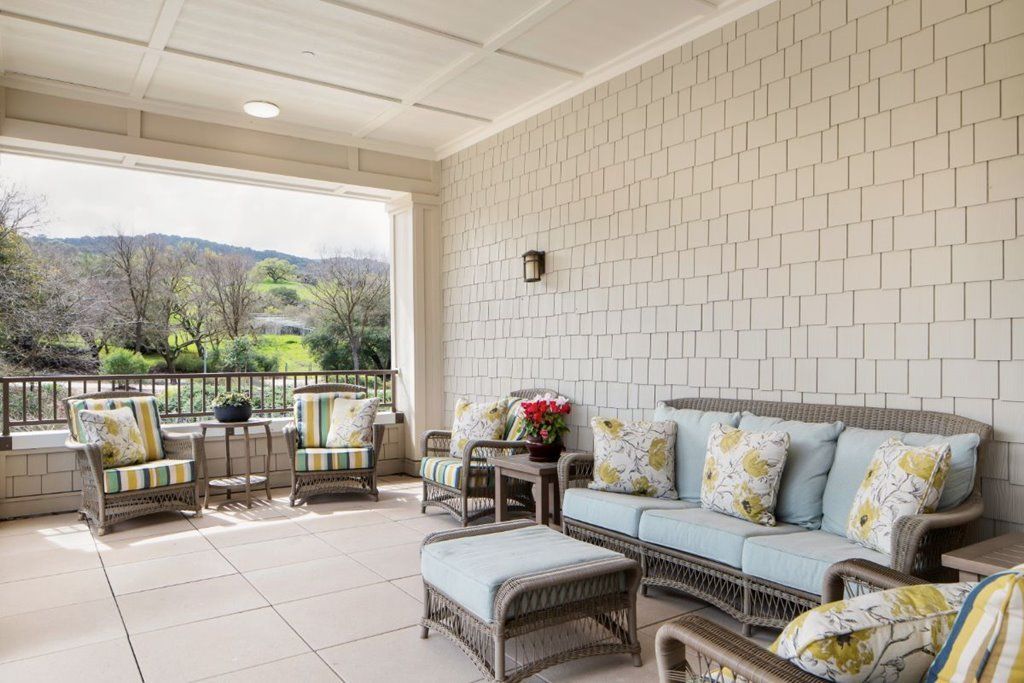 A cozy outdoor patio with comfortable seating and a scenic view.