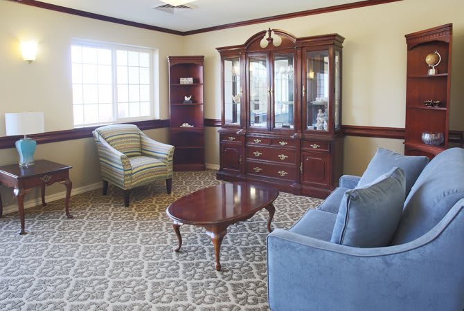 A cozy living room with classic furniture and a large window.