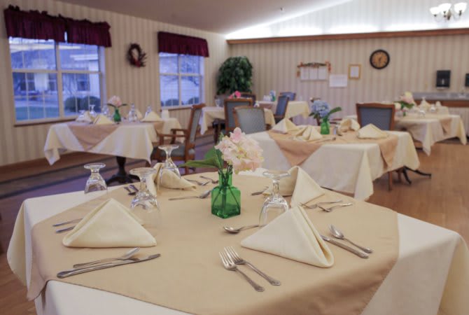 A neatly arranged dining room with elegantly folded napkins and a cozy atmosphere.