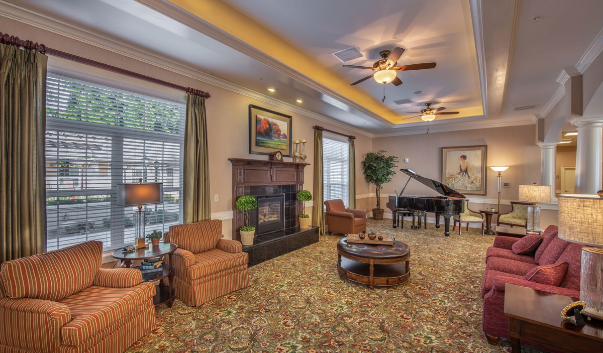 A cozy living room with a fireplace, piano, and comfortable seating.