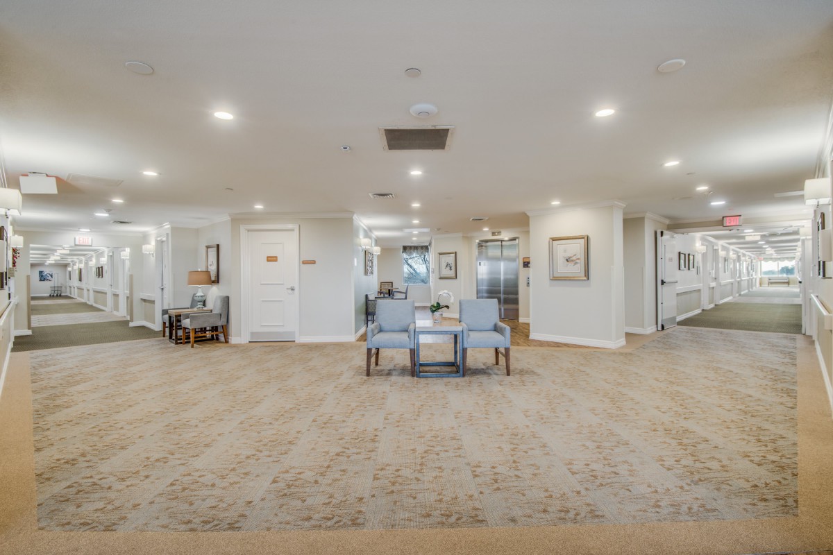 A spacious lobby area with seating and artwork on the walls.