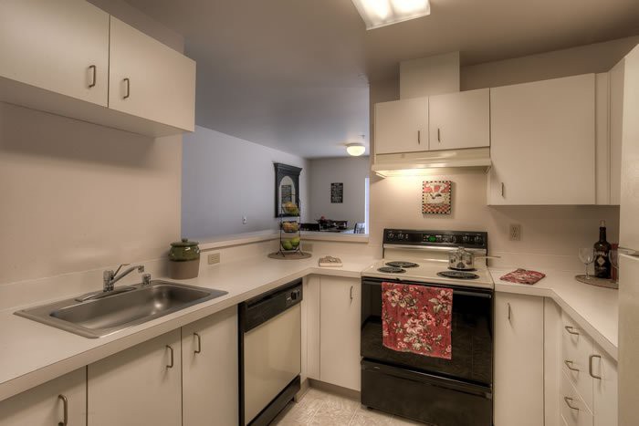 A modern kitchen with light cabinets and appliances.