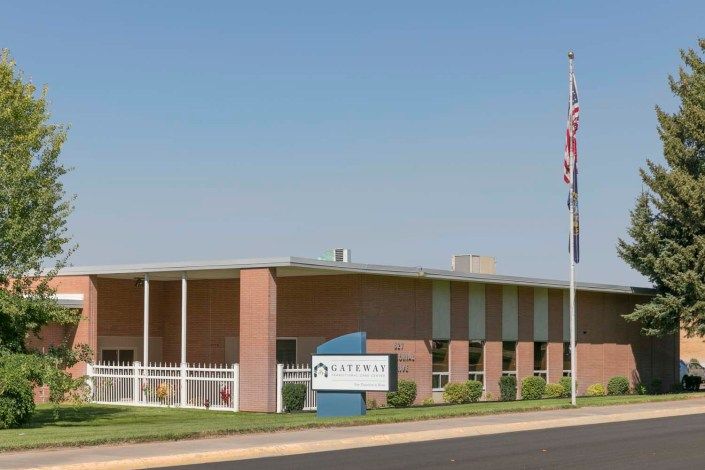A commercial building with signage and flagpole outside.