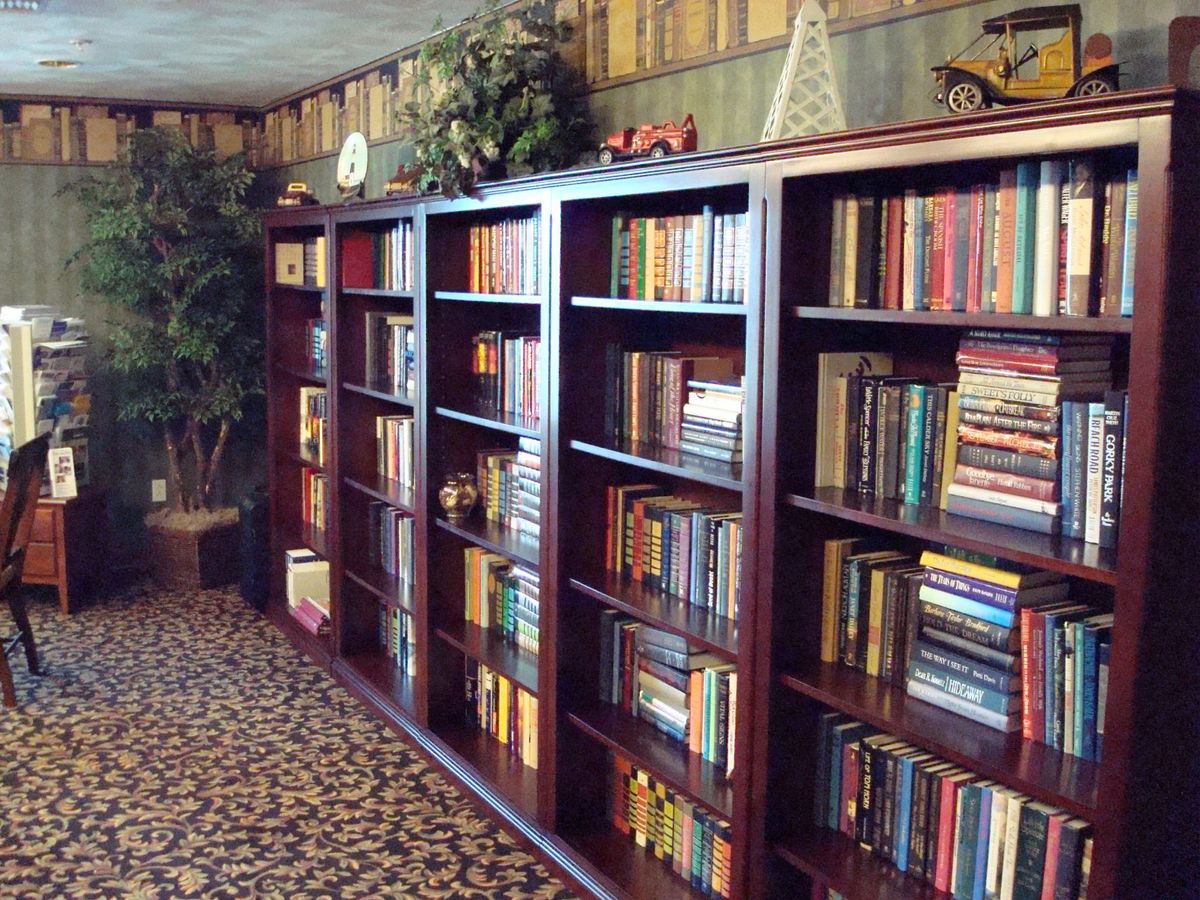 A cozy library corner with wooden bookshelves filled with an assortment of books.