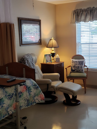 A cozy and well-furnished room featuring a bed, seating area, and decorative elements.