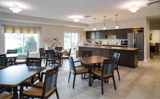 A bright and spacious dining area featuring modern furnishings and an open kitchen.