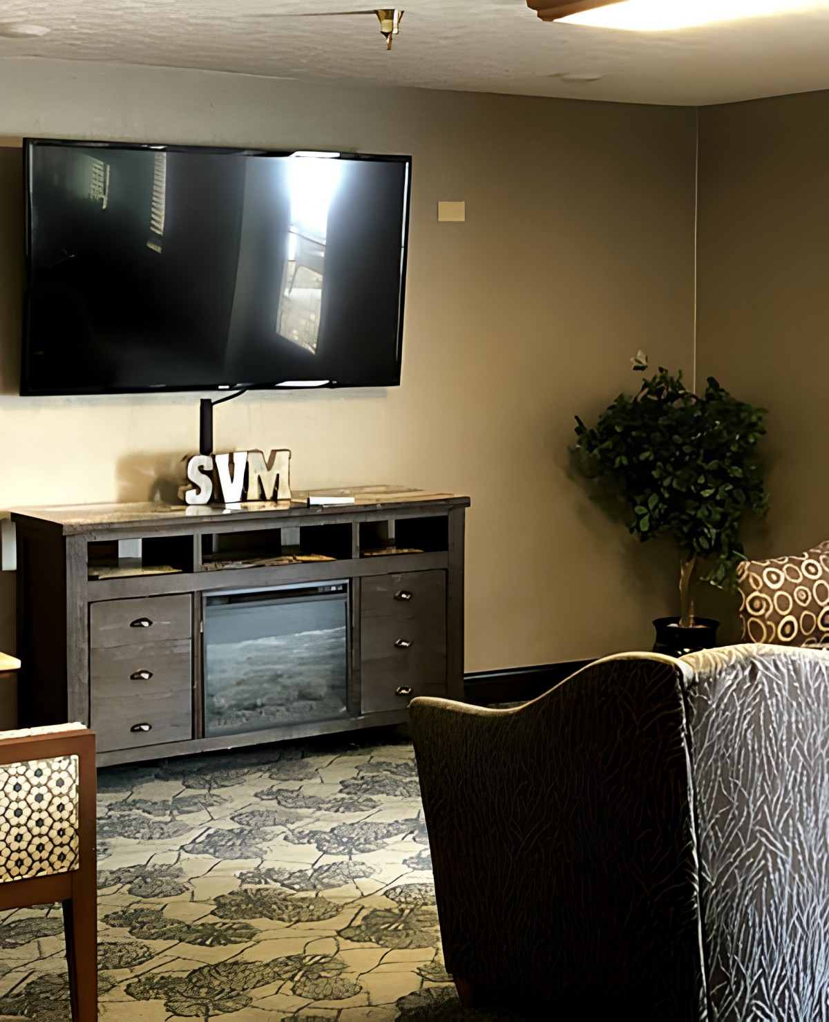 A cozy living room with a mounted TV and stylish furniture.
