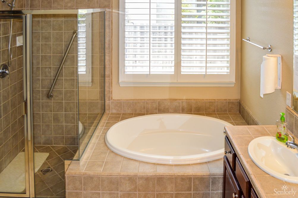 A modern bathroom with a round bathtub and tiled walls.