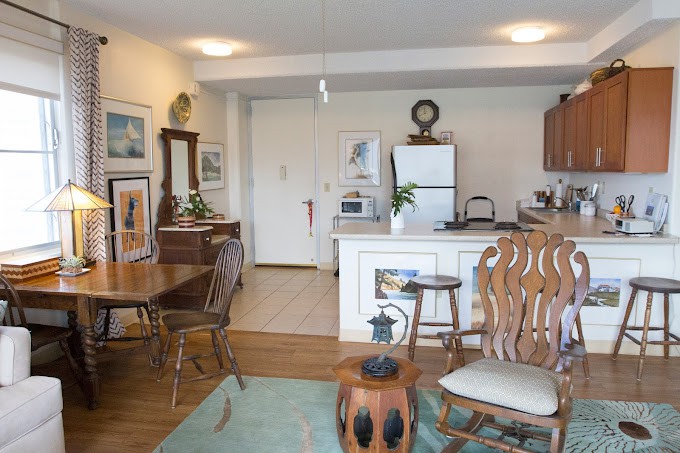 A cozy open-concept living and dining area with a kitchen in the background.