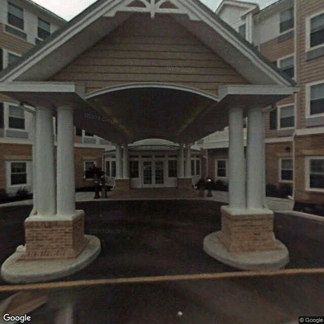 The image shows the entrance of a building with a covered canopy supported by columns.