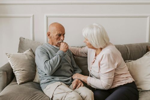 An elderly couple engages in a heartfelt conversation, showcasing care and support for one another.