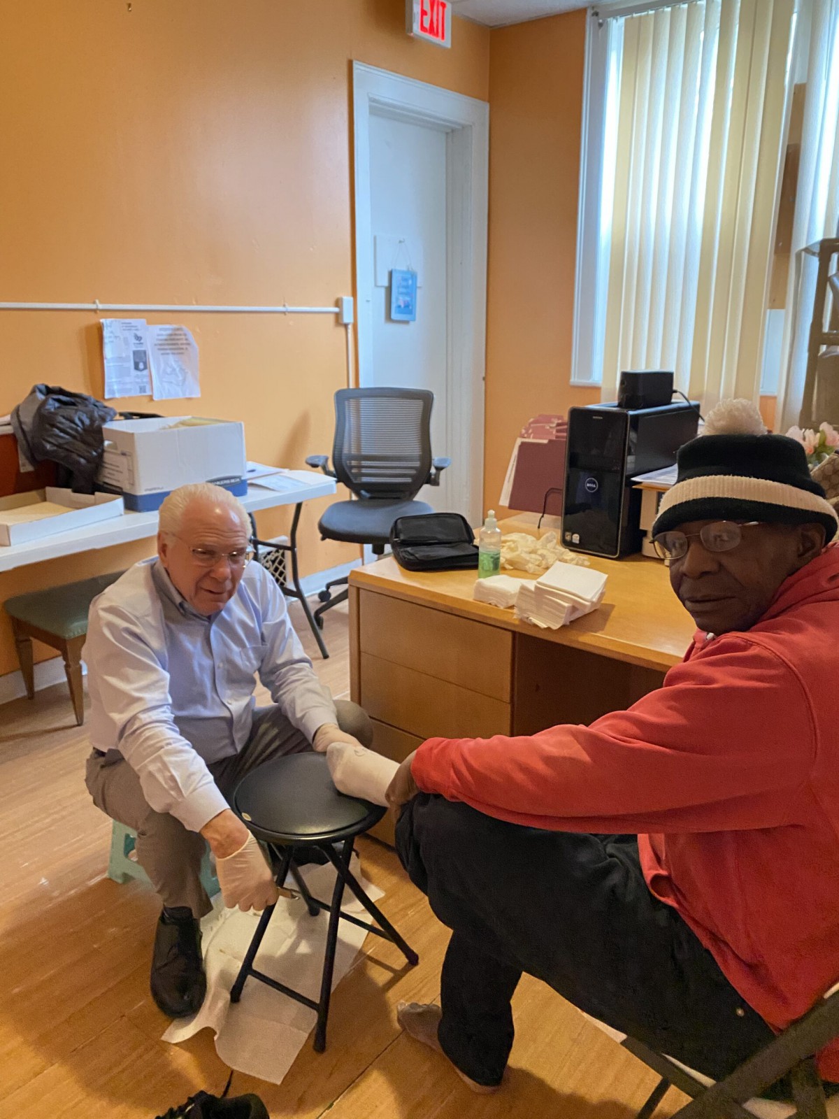 Two individuals in an office setting engaged in a conversation.