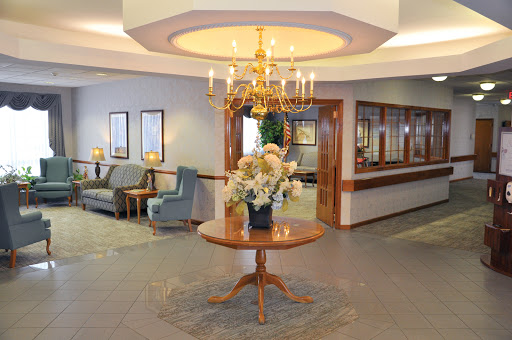 A beautifully decorated lobby featuring elegant furniture and floral arrangements under a chandelier.