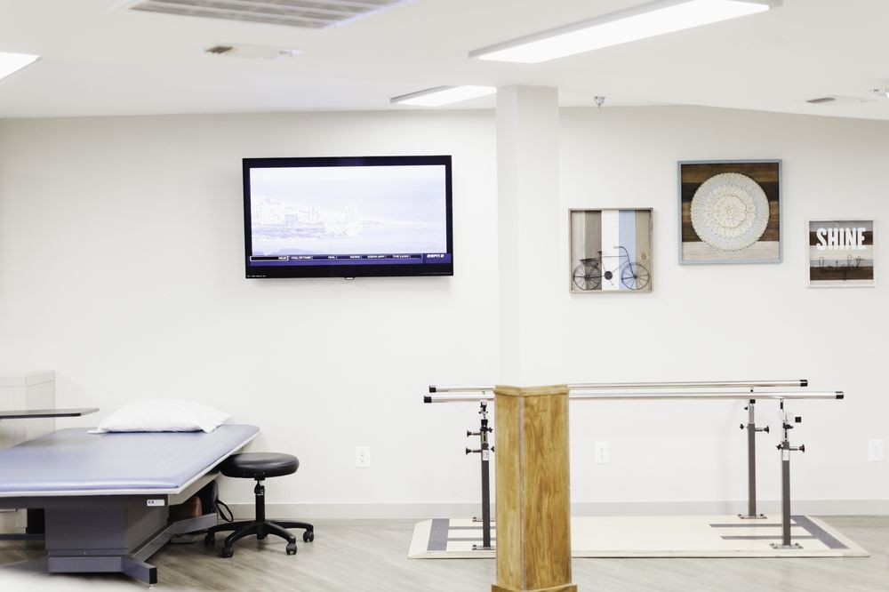 A modern rehabilitation clinic with exercise equipment and a treatment table.