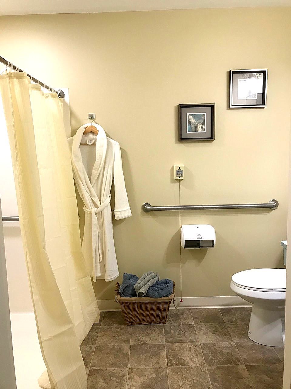 A well-organized bathroom with a shower, robe, and towels.