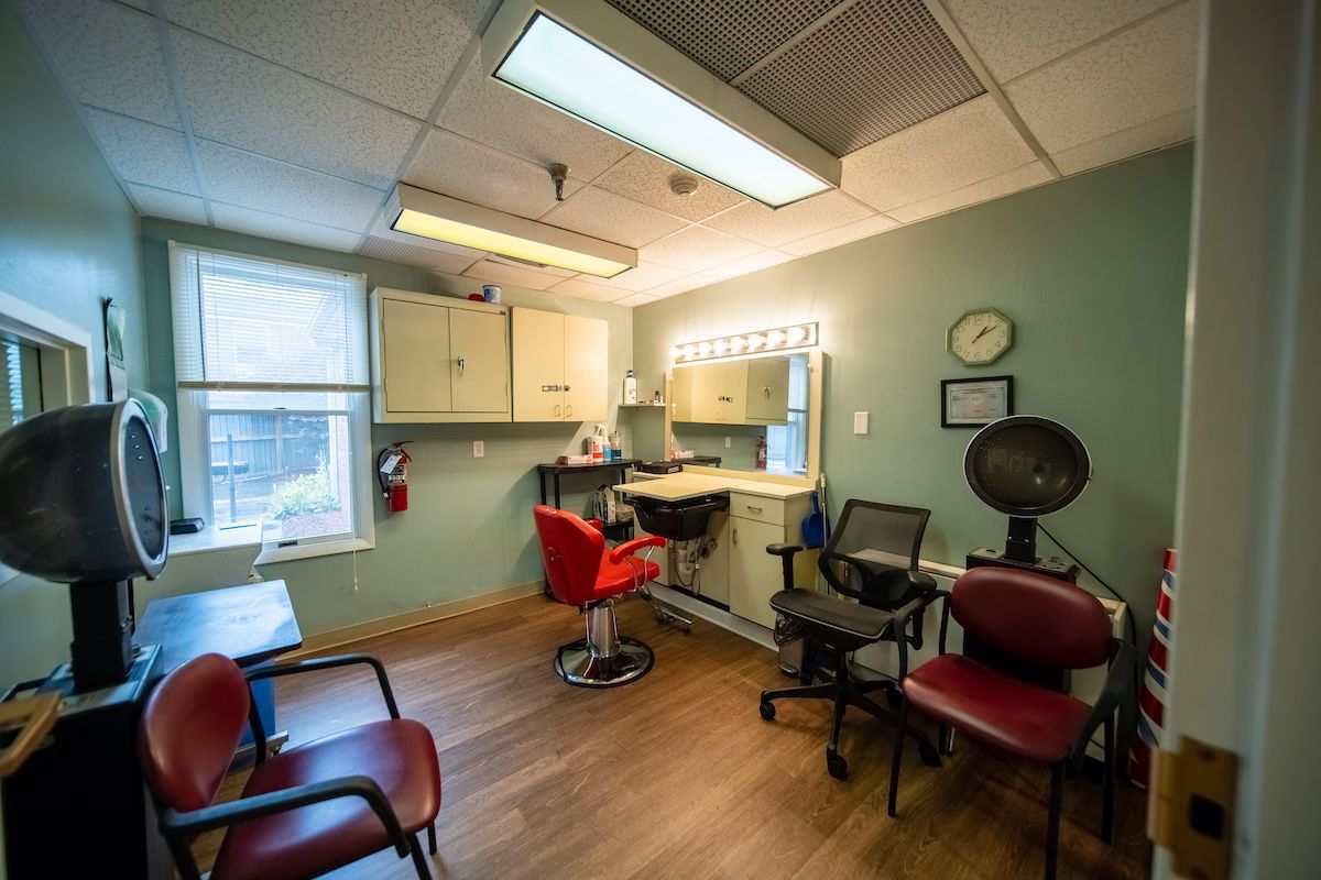 A cozy hair salon interior with a styling station and waiting area.