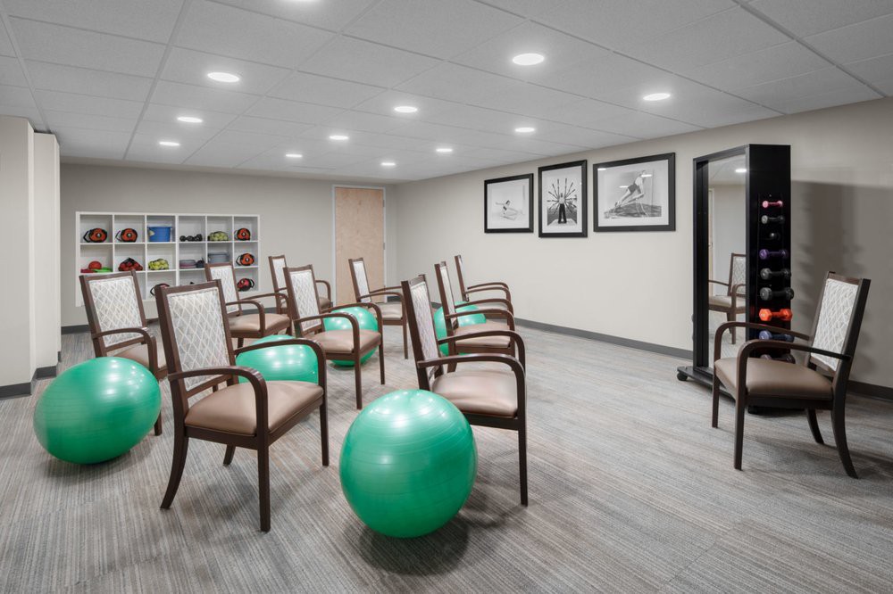 A wellness center exercise room with chairs and a fitness ball.