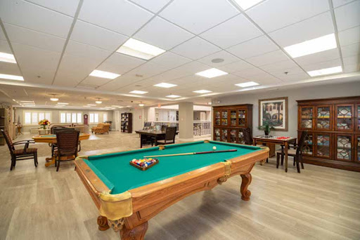 A spacious game room featuring a green felt pool table and inviting seating arrangements.