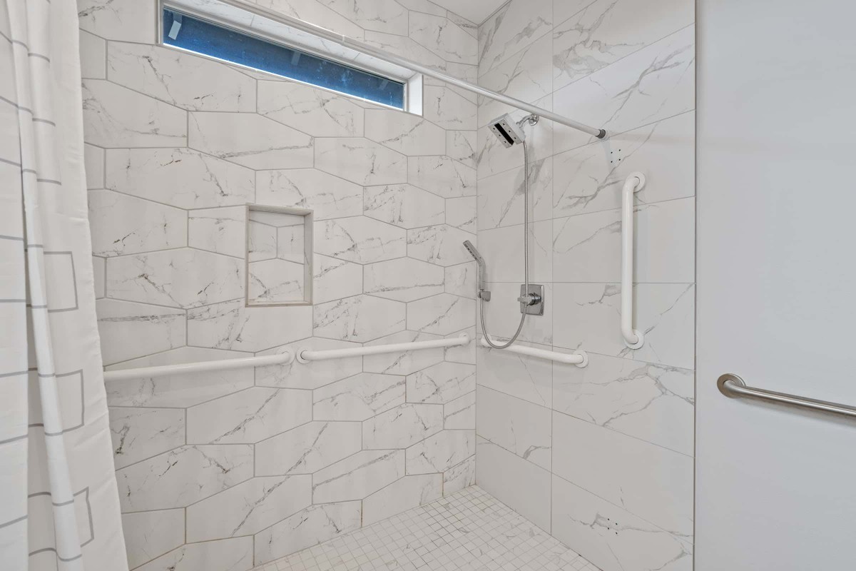 A modern walk-in shower with marble tiles and a sleek design.
