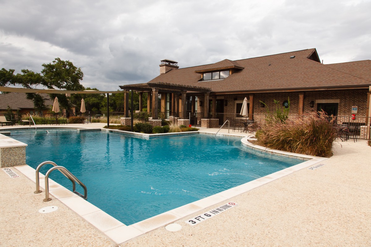 Outdoor swimming pool with a view of a residential building.