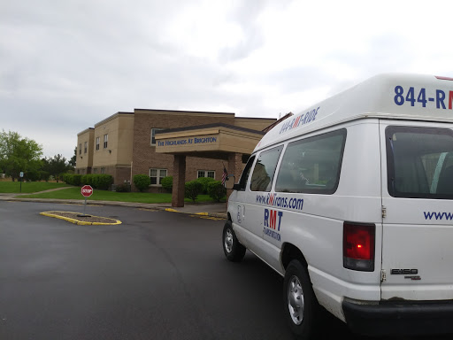 A medical transport van parked near a healthcare facility on a cloudy day.
