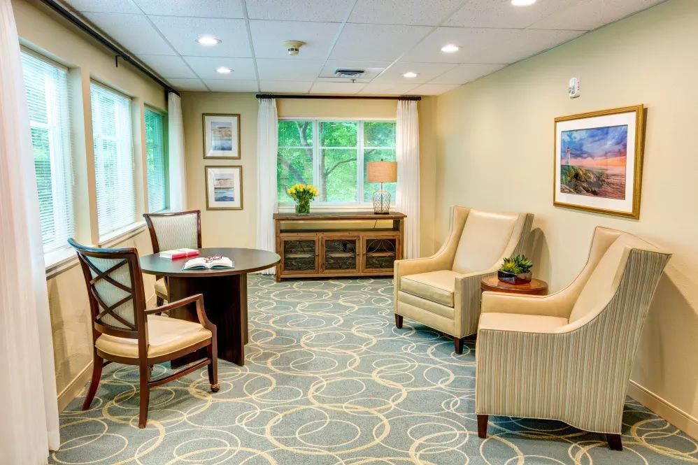 A well-lit waiting area with comfortable seating and a table.