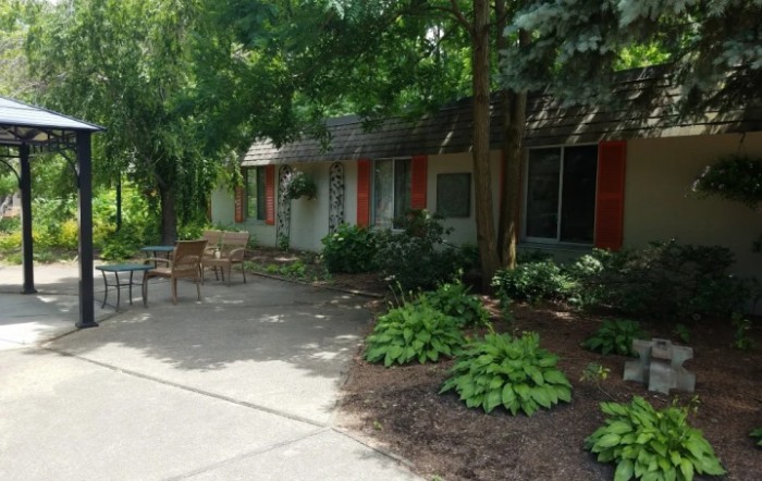 A peaceful garden area with outdoor seating and lush greenery.