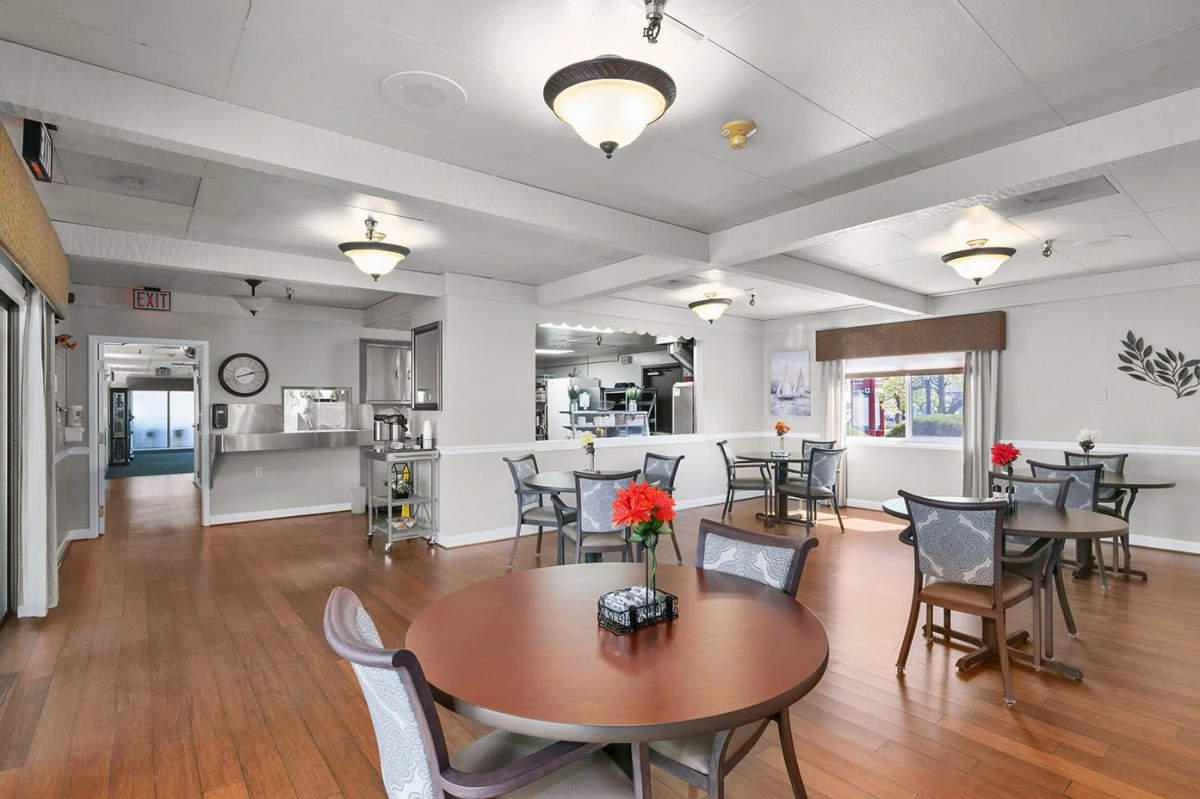 A modern dining area with round tables, chairs, and ambient lighting.