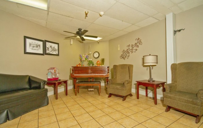 A cozy living room with a piano and comfortable seating.
