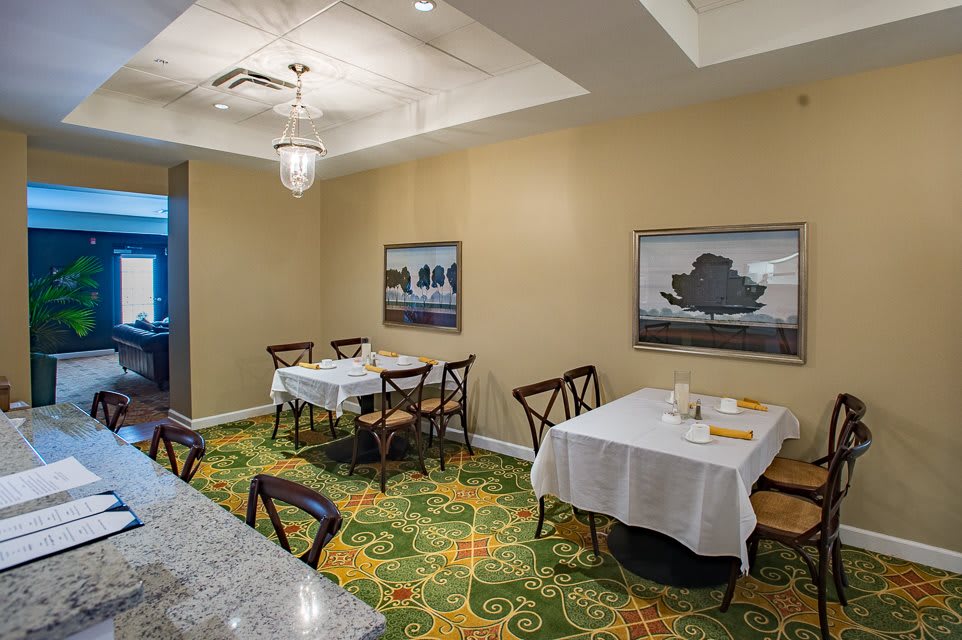 A small, elegantly decorated dining room with tables set for a meal.