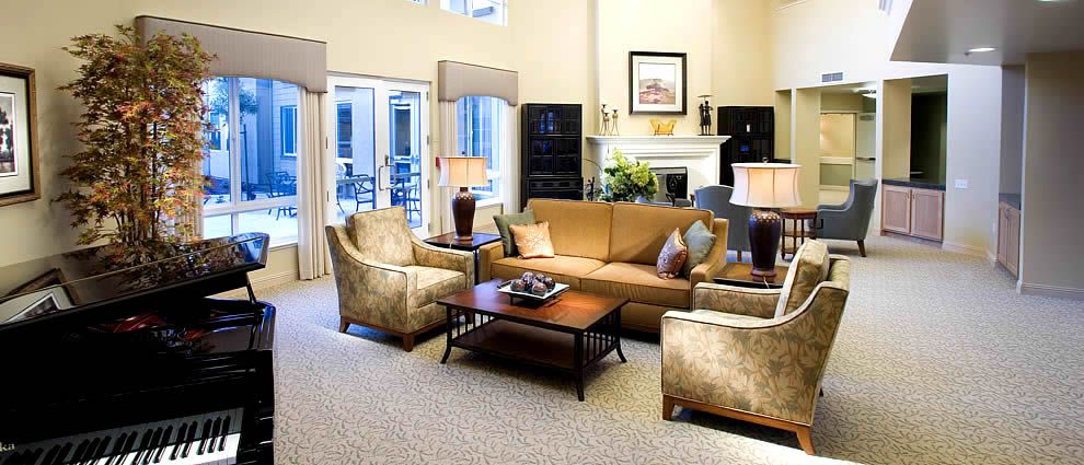 A well-decorated living room featuring a cozy sofa set, armchairs, and a coffee table, with elegant lamps and a fireplace enhancing the ambiance.
