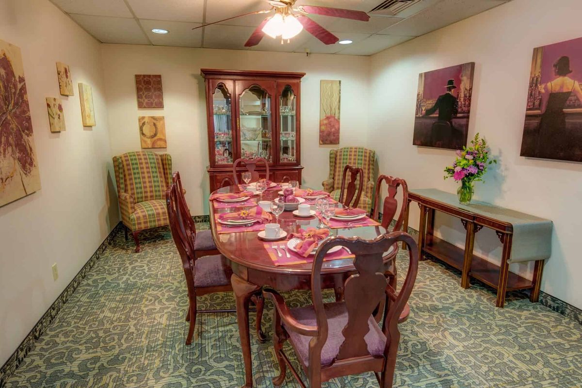 A traditional dining room setup with a large wooden table, matching chairs, and decorative elements.