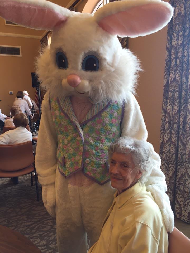 A person posing with someone in an Easter Bunny costume indoors.