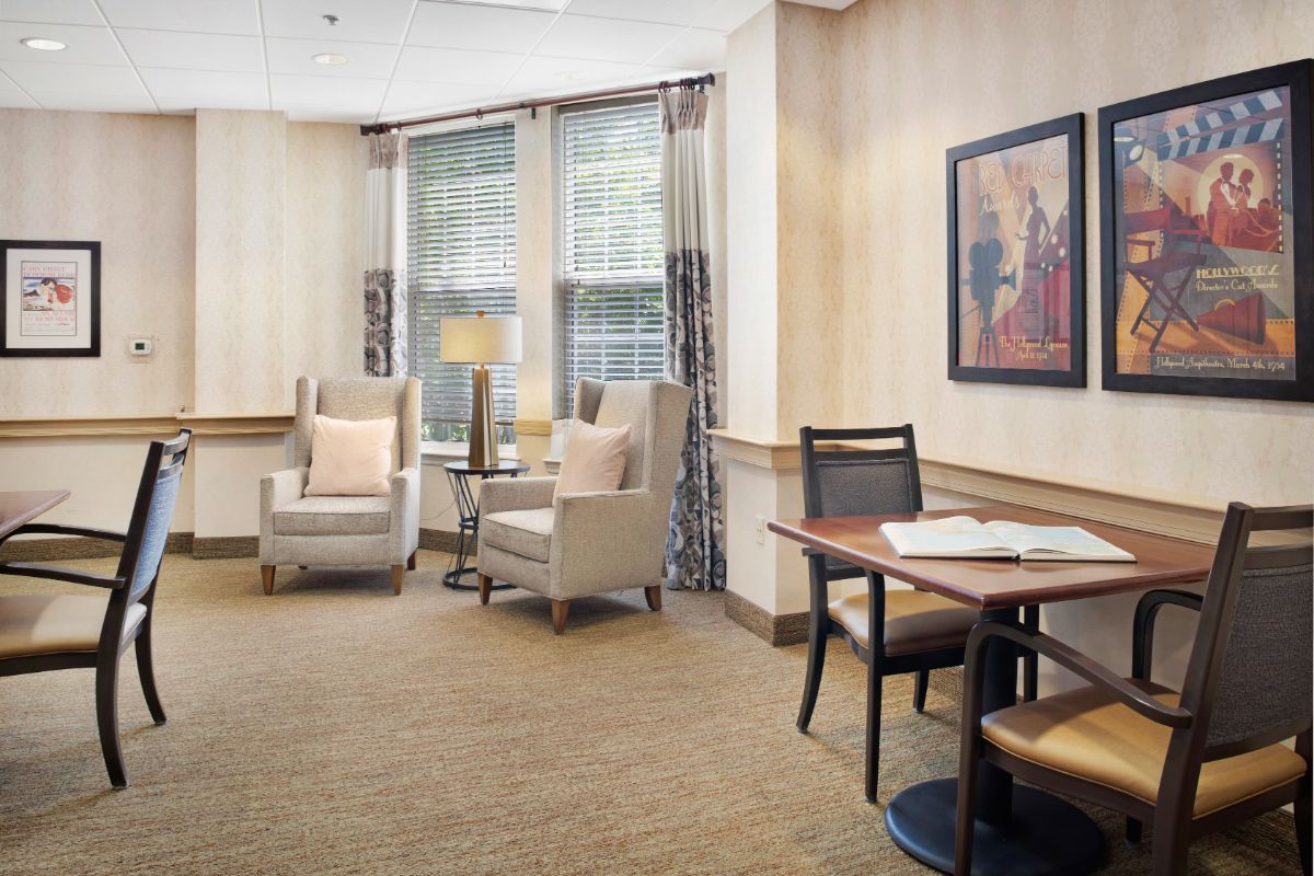 A cozy living room with comfortable chairs and a small table near large windows.