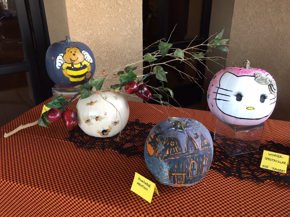 A display of creatively painted pumpkins featuring various character designs for Halloween decoration.