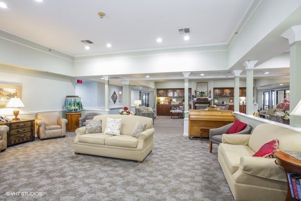 A spacious living room with comfortable sofas and bright ceiling lights.