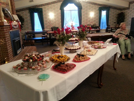 A beautifully arranged dessert table featuring an array of sweets and decorative flowers, perfect for a celebratory event.