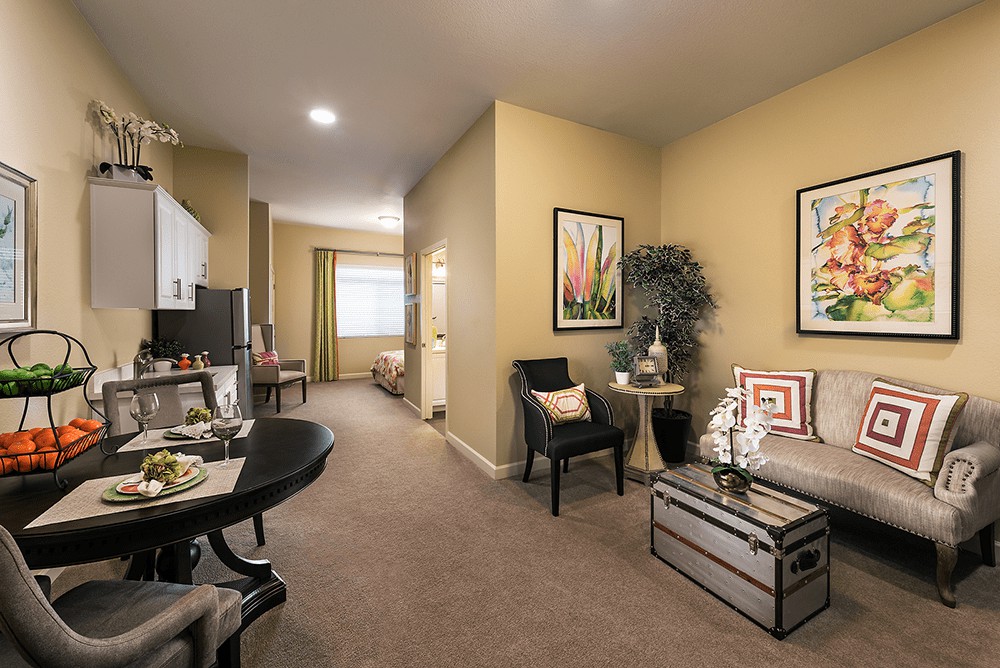 A cozy living room with neutral colors, featuring comfortable furniture and decorative artwork.