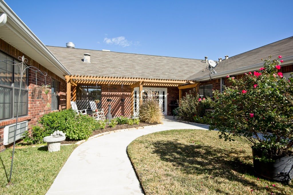 A charming house with a well-maintained garden and a winding pathway leading to the entrance.