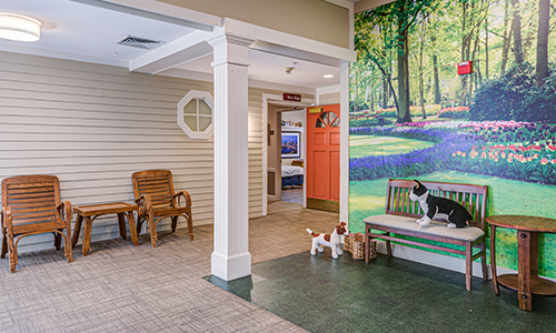 An indoor space featuring a bench with artificial pet figures and a vibrant mural of a forest scene on the wall.