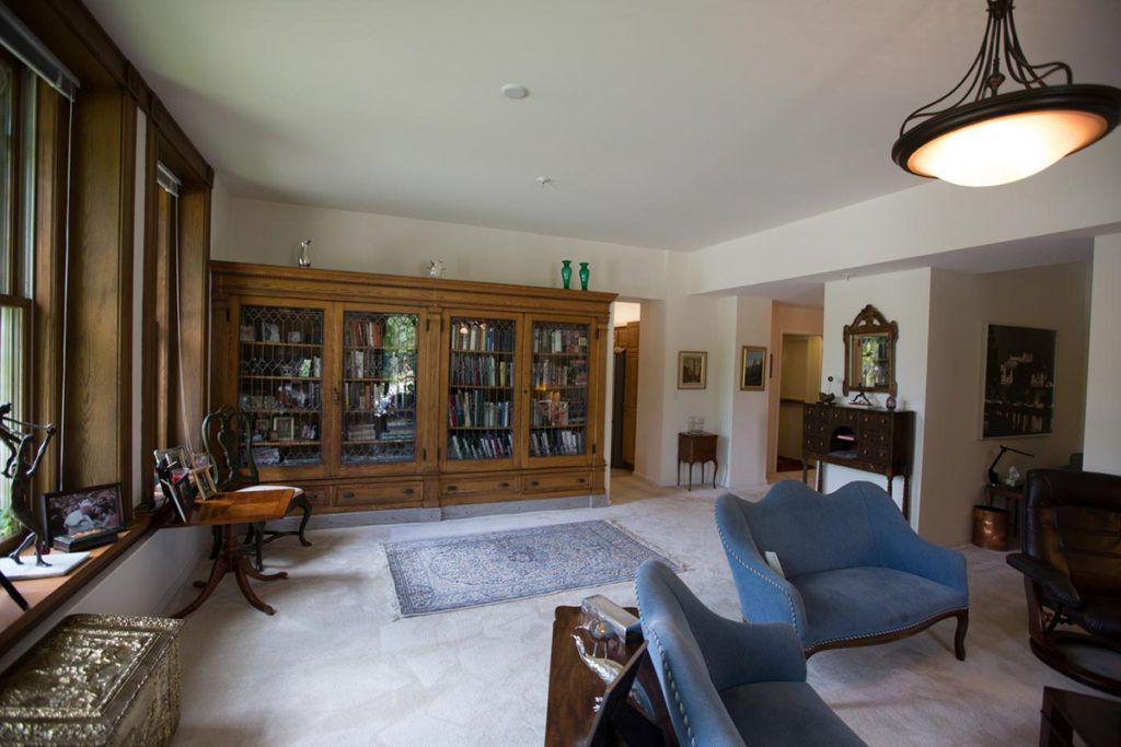 A cozy living room with large bookshelves and comfortable armchairs.