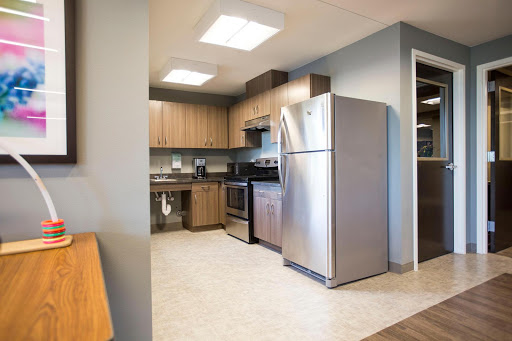 A modern kitchen featuring stainless steel appliances and wooden cabinetry.