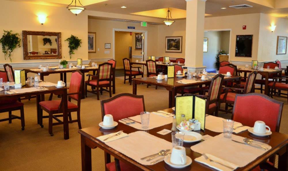 A neatly arranged restaurant dining room with tables set for guests.