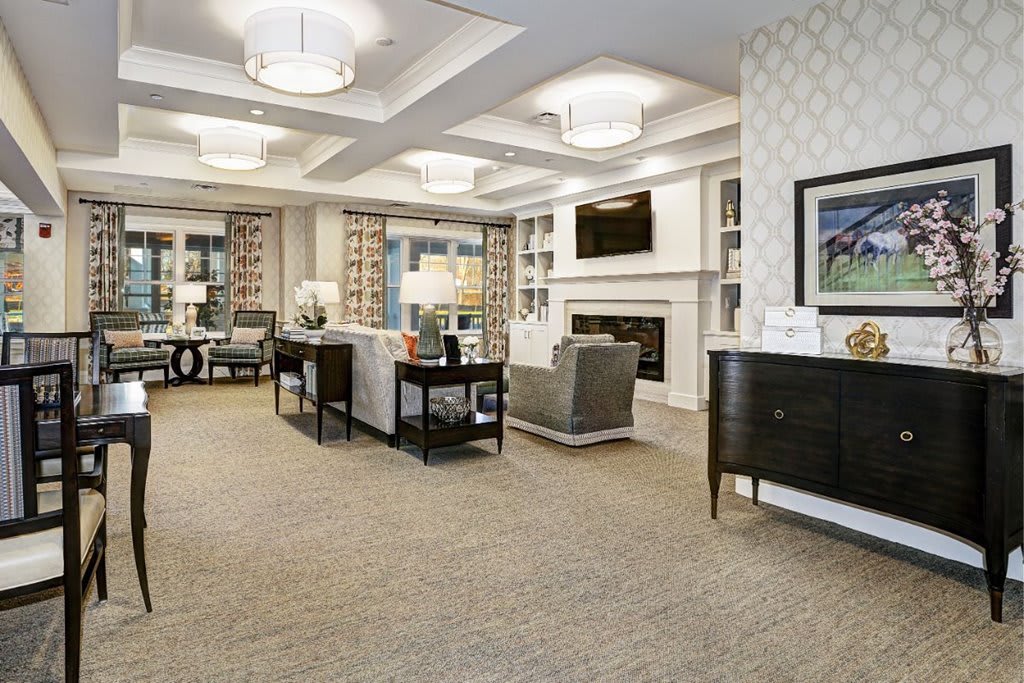 A modern and elegantly decorated living room featuring comfortable seating, a fireplace, and soft lighting.