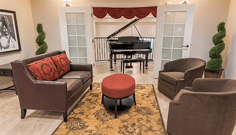 A cozy living room with a grand piano, comfortable seating, and elegant decor.
