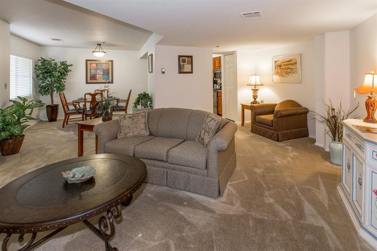 A cozy living room with a sofa, coffee table, and adjacent dining area.
