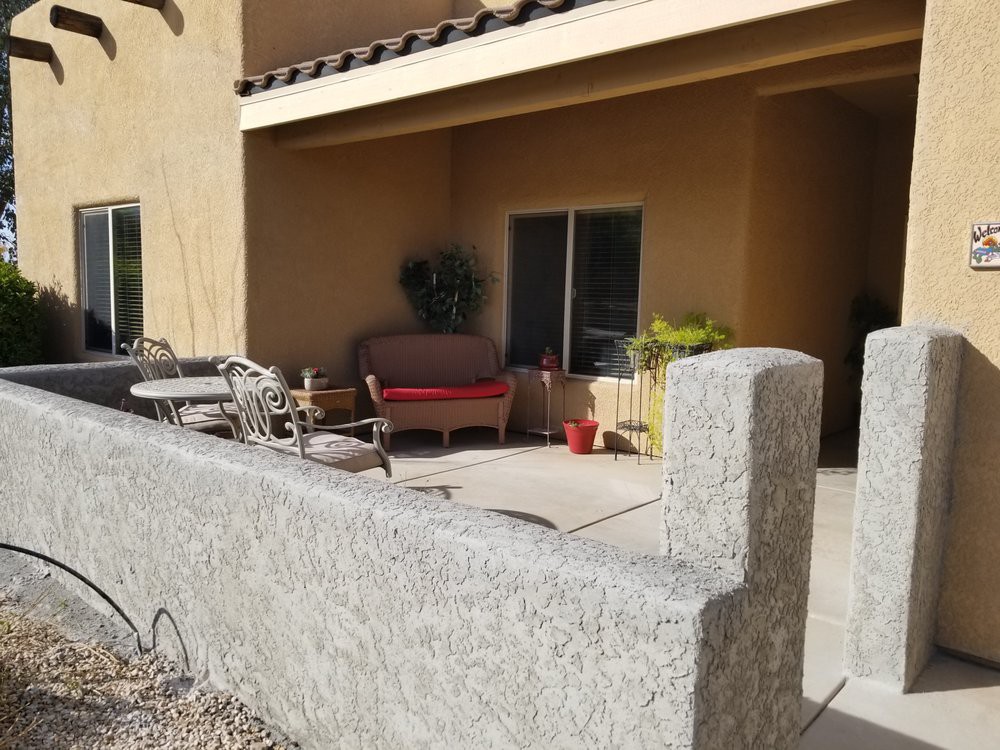 A sunny patio with outdoor furniture and potted plants.