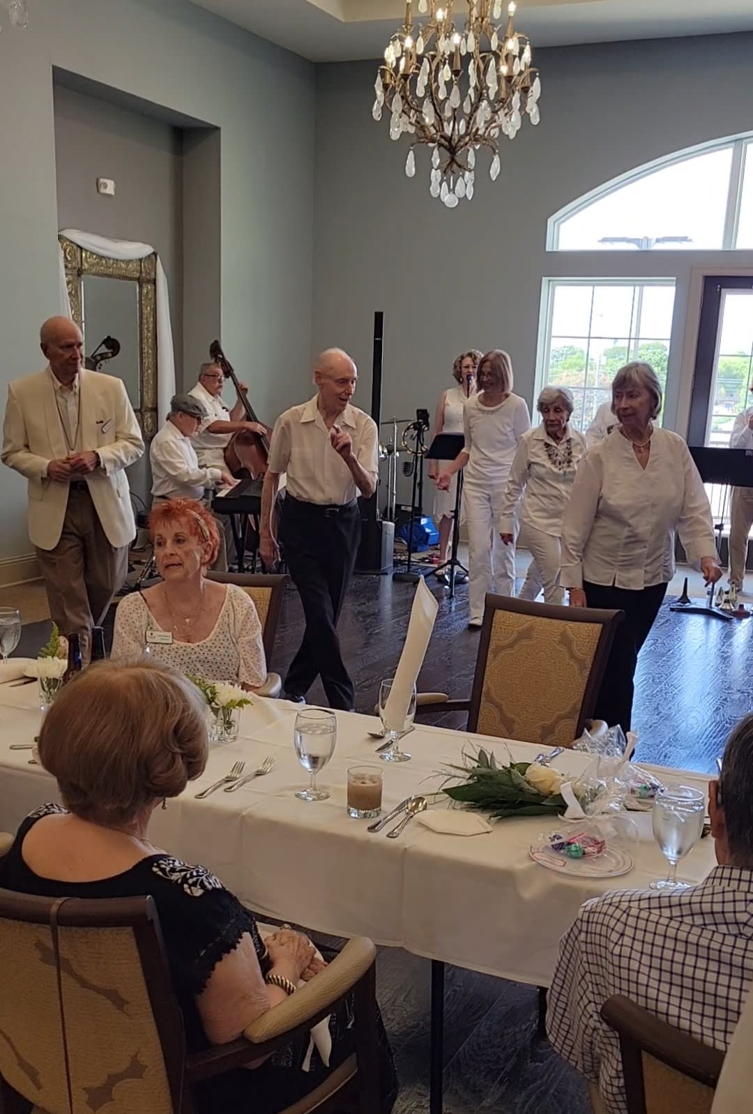 A group of people enjoying a gathering with music and dining indoors.